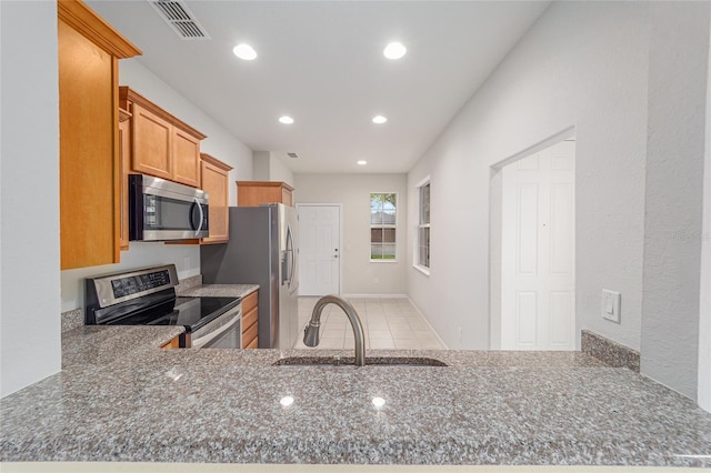 kitchen featuring visible vents, recessed lighting, stone countertops, stainless steel appliances, and a sink