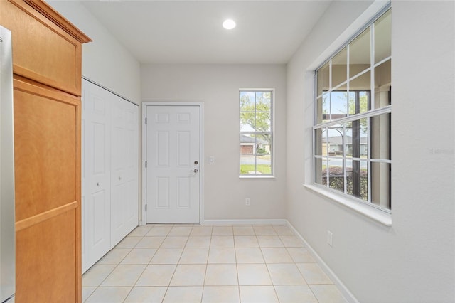 entrance foyer featuring light tile patterned floors, baseboards, and recessed lighting