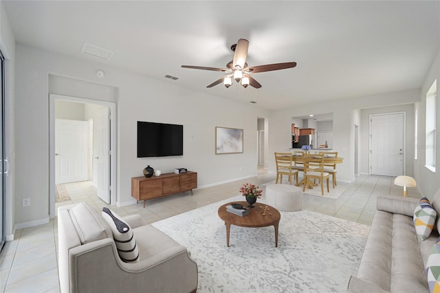 living room featuring a ceiling fan, light tile patterned floors, baseboards, and visible vents