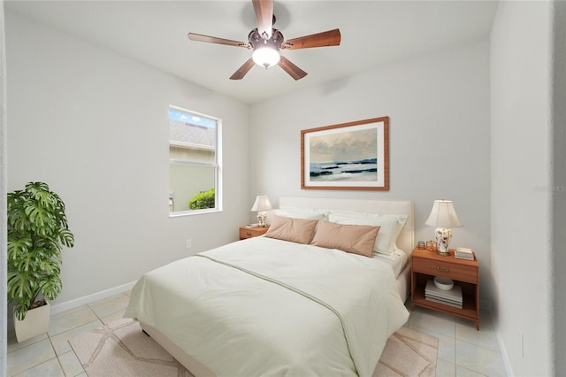 bedroom featuring baseboards, light tile patterned flooring, and a ceiling fan