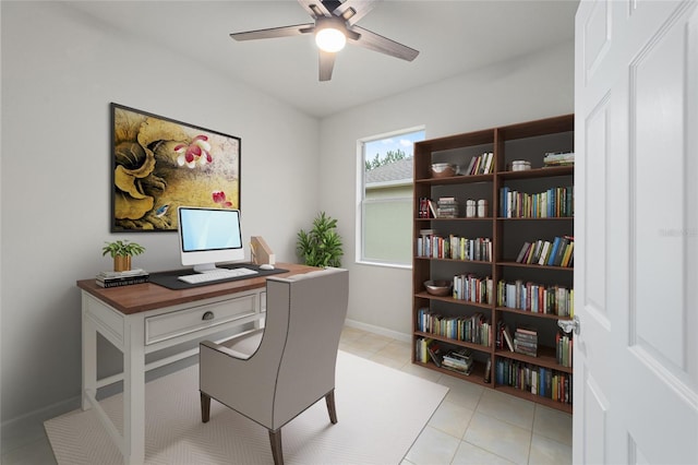 home office featuring light tile patterned floors, a ceiling fan, and baseboards