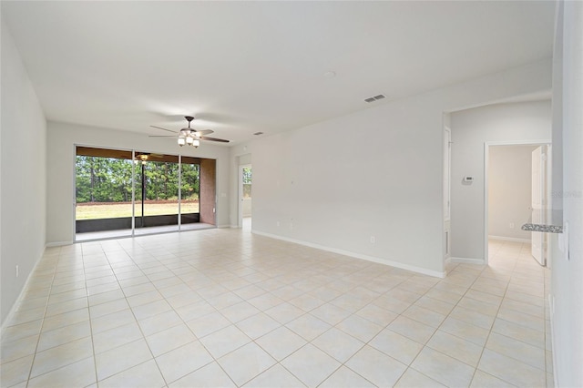 unfurnished room featuring light tile patterned floors, visible vents, baseboards, and ceiling fan