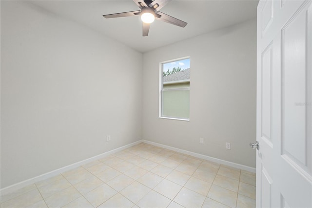 empty room featuring light tile patterned floors, a ceiling fan, and baseboards