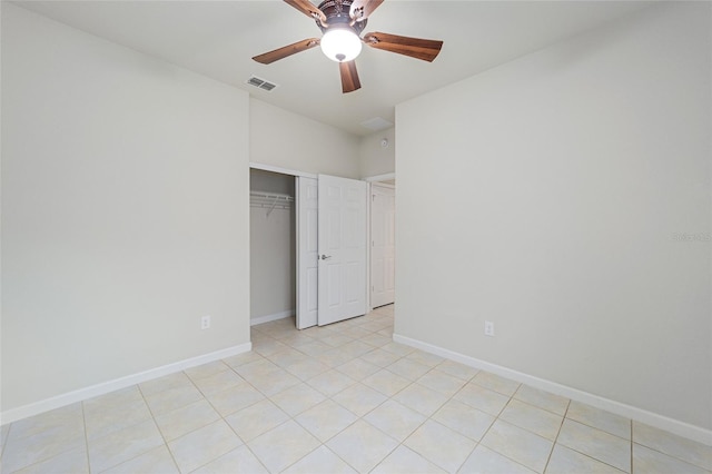 unfurnished bedroom featuring visible vents, a closet, light tile patterned flooring, baseboards, and ceiling fan