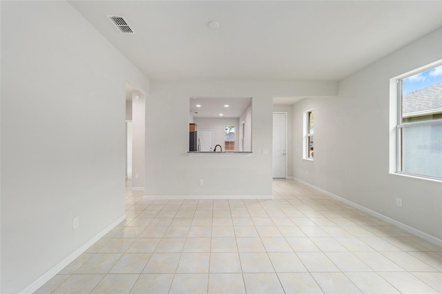 spare room featuring light tile patterned flooring, baseboards, and visible vents