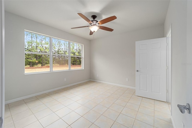 spare room featuring light tile patterned floors, ceiling fan, and baseboards