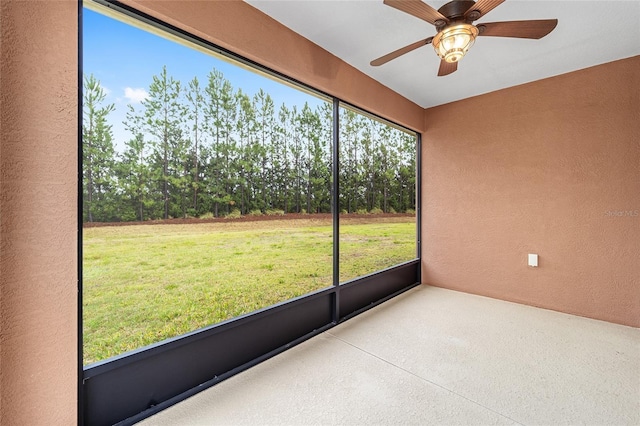 unfurnished sunroom with ceiling fan