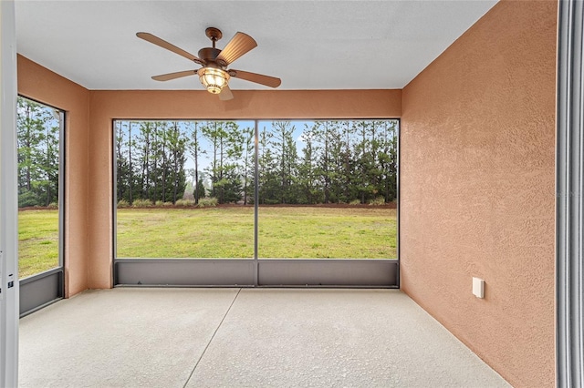 unfurnished sunroom with ceiling fan