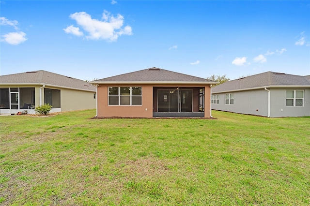 back of property with stucco siding, a lawn, and a sunroom