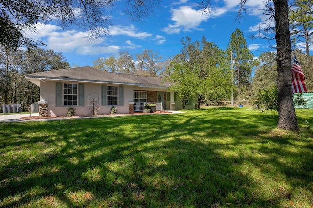 rear view of house featuring a lawn and stucco siding