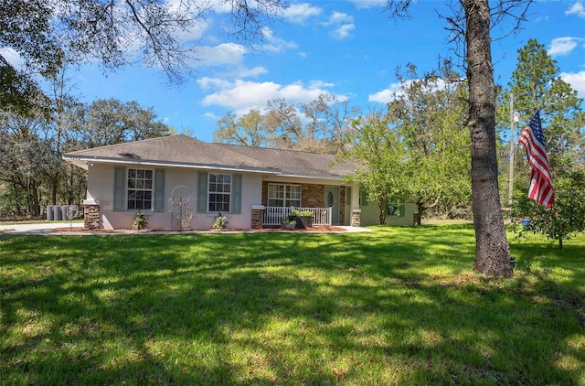 ranch-style home featuring covered porch, stucco siding, a front yard, and central AC unit