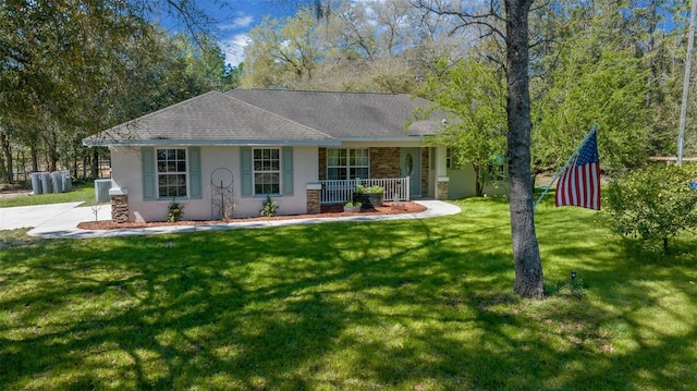 ranch-style house with stucco siding, covered porch, a front yard, and a shingled roof