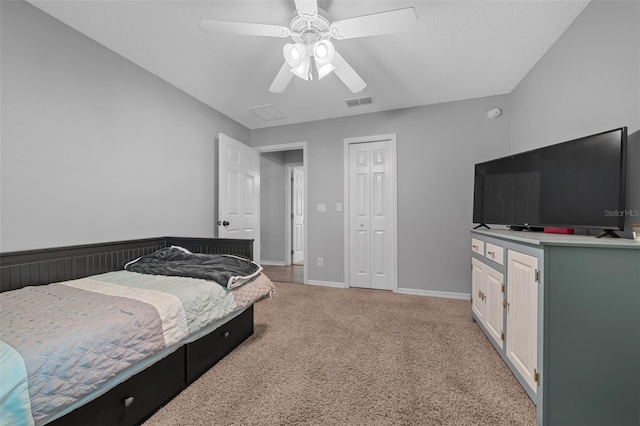 bedroom with visible vents, a closet, baseboards, light colored carpet, and ceiling fan