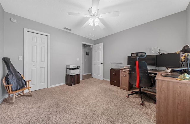 office space featuring a ceiling fan, baseboards, visible vents, and light carpet