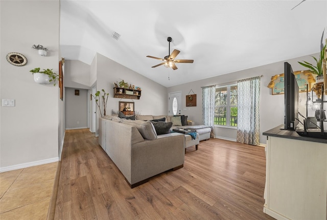 living area featuring a ceiling fan, wood finished floors, visible vents, baseboards, and vaulted ceiling