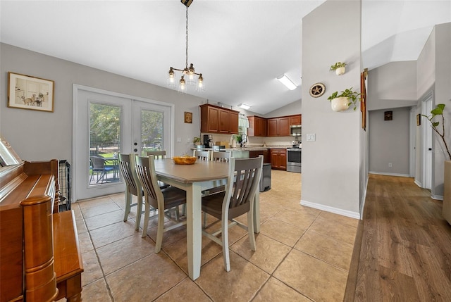 dining space featuring light tile patterned floors, french doors, high vaulted ceiling, and baseboards