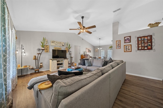 living area with visible vents, baseboards, vaulted ceiling, wood finished floors, and a ceiling fan