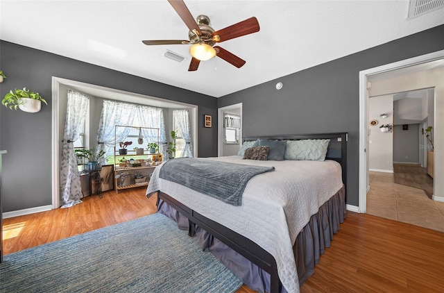 bedroom with visible vents, baseboards, and wood finished floors