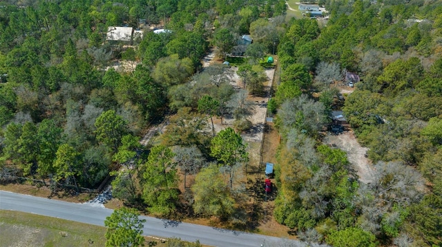 bird's eye view with a wooded view