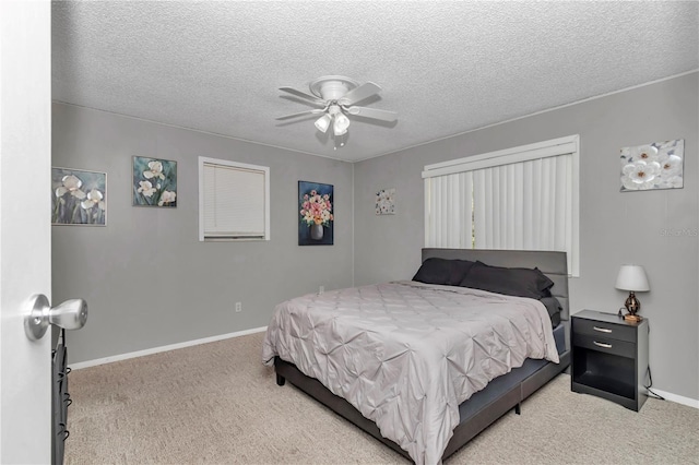 carpeted bedroom featuring a textured ceiling, baseboards, and a ceiling fan