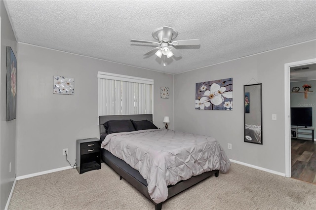 bedroom featuring visible vents, ceiling fan, baseboards, carpet flooring, and a textured ceiling