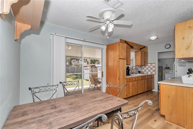 dining room featuring visible vents, independent washer and dryer, a textured ceiling, light wood finished floors, and ceiling fan