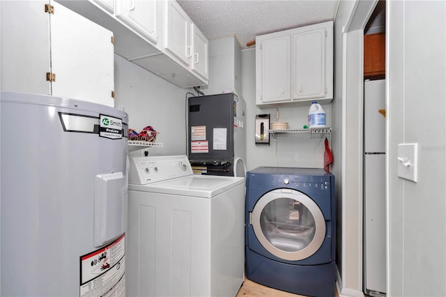 washroom with washer and dryer, cabinet space, a textured ceiling, and water heater