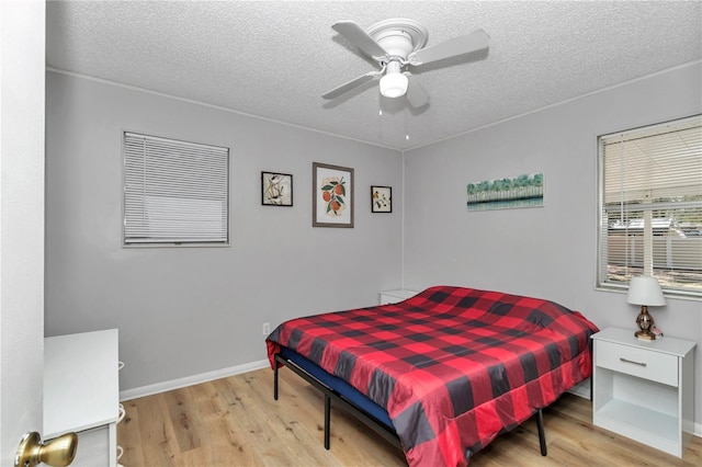 bedroom with a textured ceiling, ceiling fan, and wood finished floors