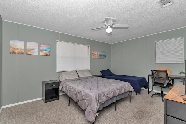 carpeted bedroom with visible vents, a textured ceiling, and a ceiling fan