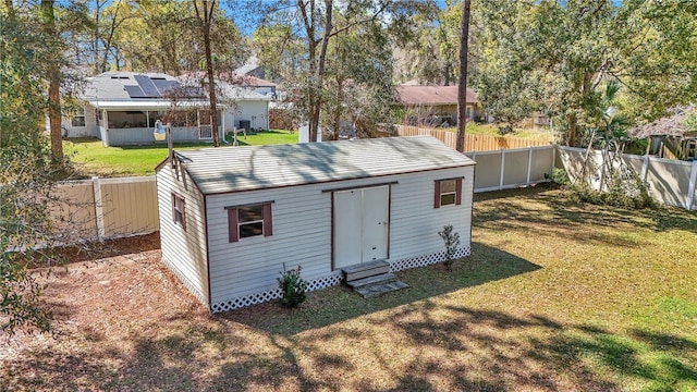 view of outdoor structure featuring an outbuilding, a fenced backyard, and entry steps