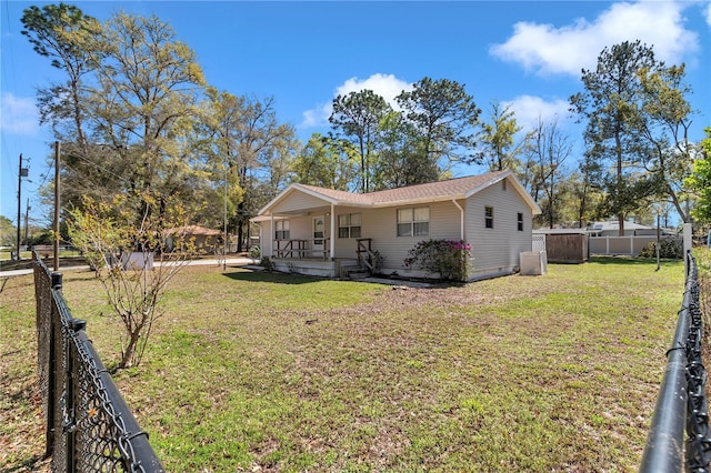 back of house featuring covered porch, fence private yard, and a lawn