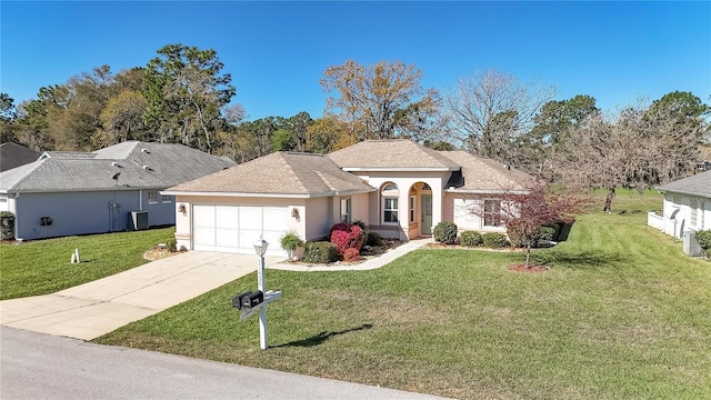 view of front of house with stucco siding, concrete driveway, a front yard, an attached garage, and central AC unit