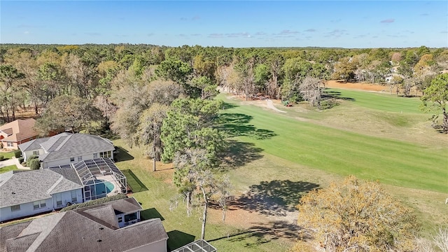 drone / aerial view featuring view of golf course and a wooded view