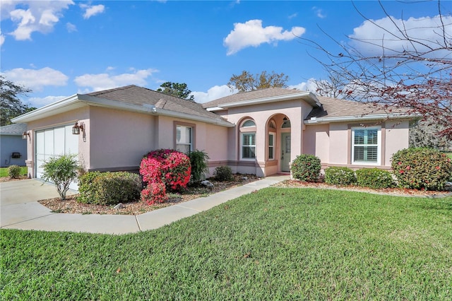 view of front of house featuring stucco siding, concrete driveway, a front yard, a shingled roof, and a garage