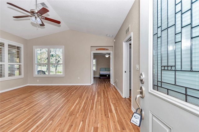 entryway featuring light wood finished floors, visible vents, baseboards, ceiling fan, and lofted ceiling