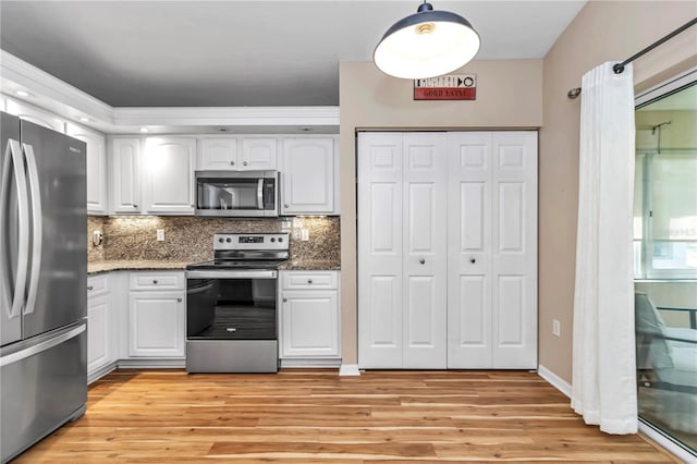 kitchen with white cabinets, appliances with stainless steel finishes, and light wood-style floors