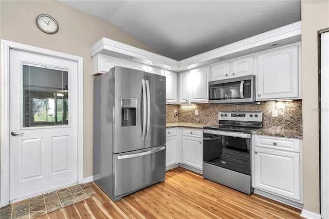 kitchen featuring decorative backsplash, light wood-style flooring, appliances with stainless steel finishes, and white cabinetry