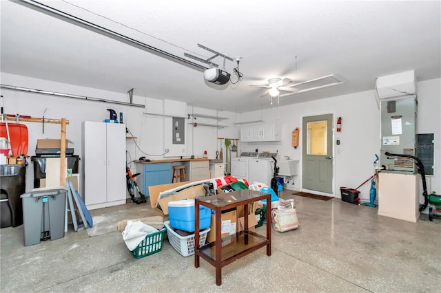 garage featuring a ceiling fan, a sink, electric panel, a garage door opener, and washing machine and dryer