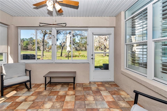 sunroom with a ceiling fan, plenty of natural light, and wood ceiling