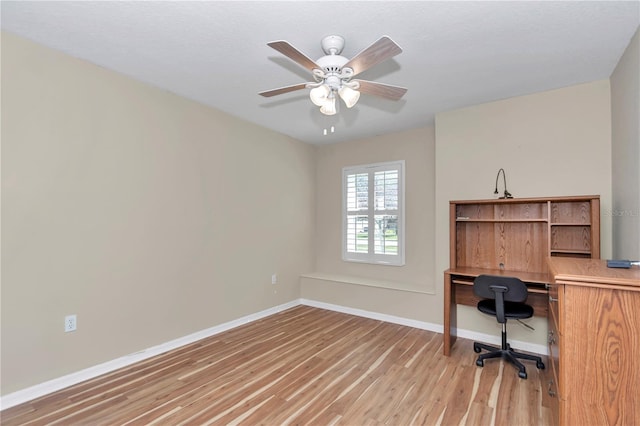 unfurnished office featuring baseboards, light wood-style floors, and a ceiling fan