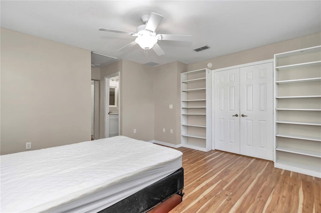 bedroom with a ceiling fan, visible vents, light wood-type flooring, and baseboards