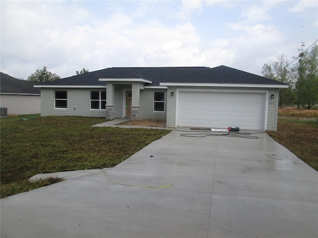 view of front of house featuring a garage, a front lawn, roof with shingles, and driveway