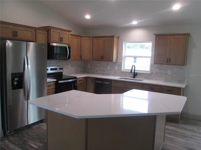 kitchen with light countertops, tasteful backsplash, vaulted ceiling, stainless steel appliances, and a sink