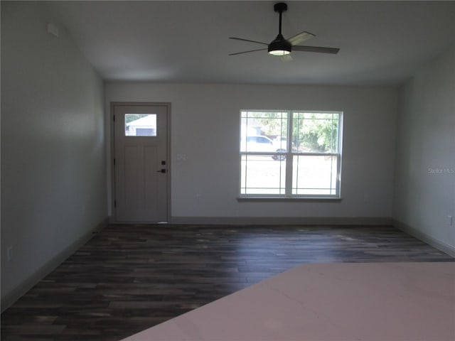 foyer with baseboards, a ceiling fan, and dark wood-style flooring
