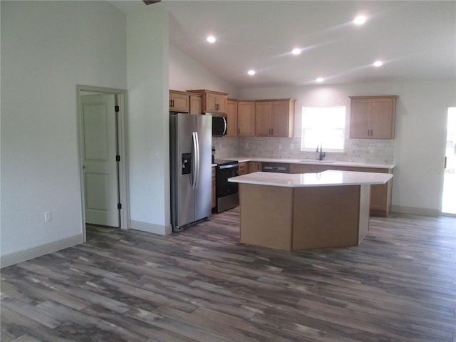 kitchen featuring light countertops, a center island, appliances with stainless steel finishes, and decorative backsplash