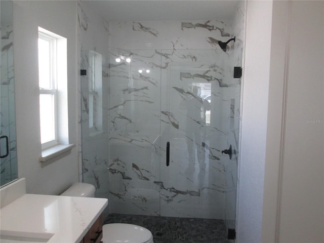 full bathroom with toilet, vanity, and a marble finish shower