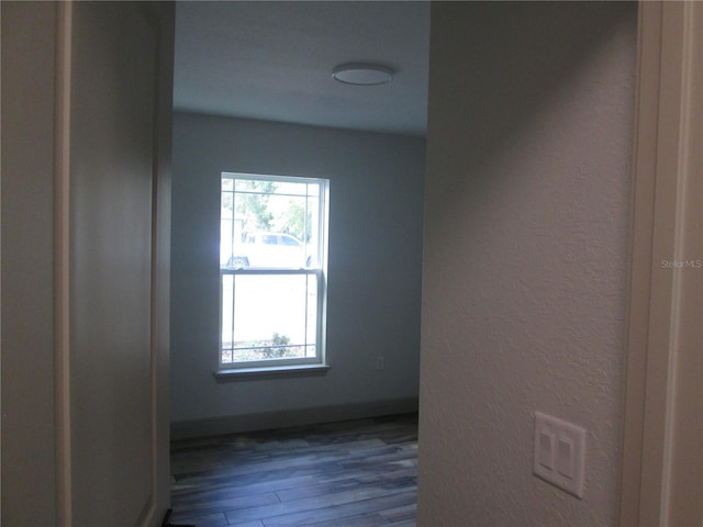 unfurnished room with baseboards and wood finished floors