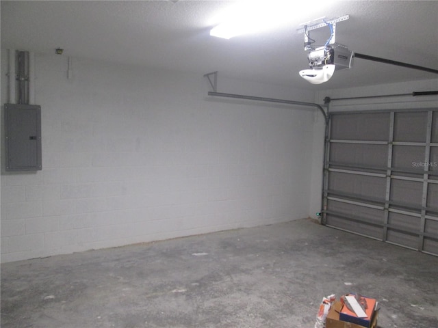 garage featuring concrete block wall, a garage door opener, and electric panel