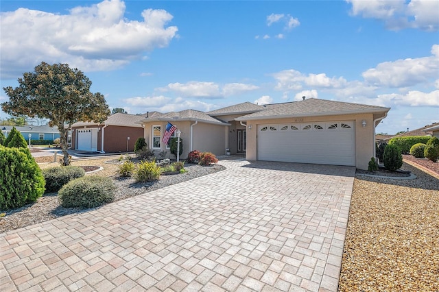 view of front of property with stucco siding, decorative driveway, and a garage