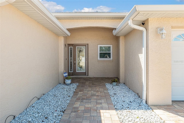 view of exterior entry with stucco siding